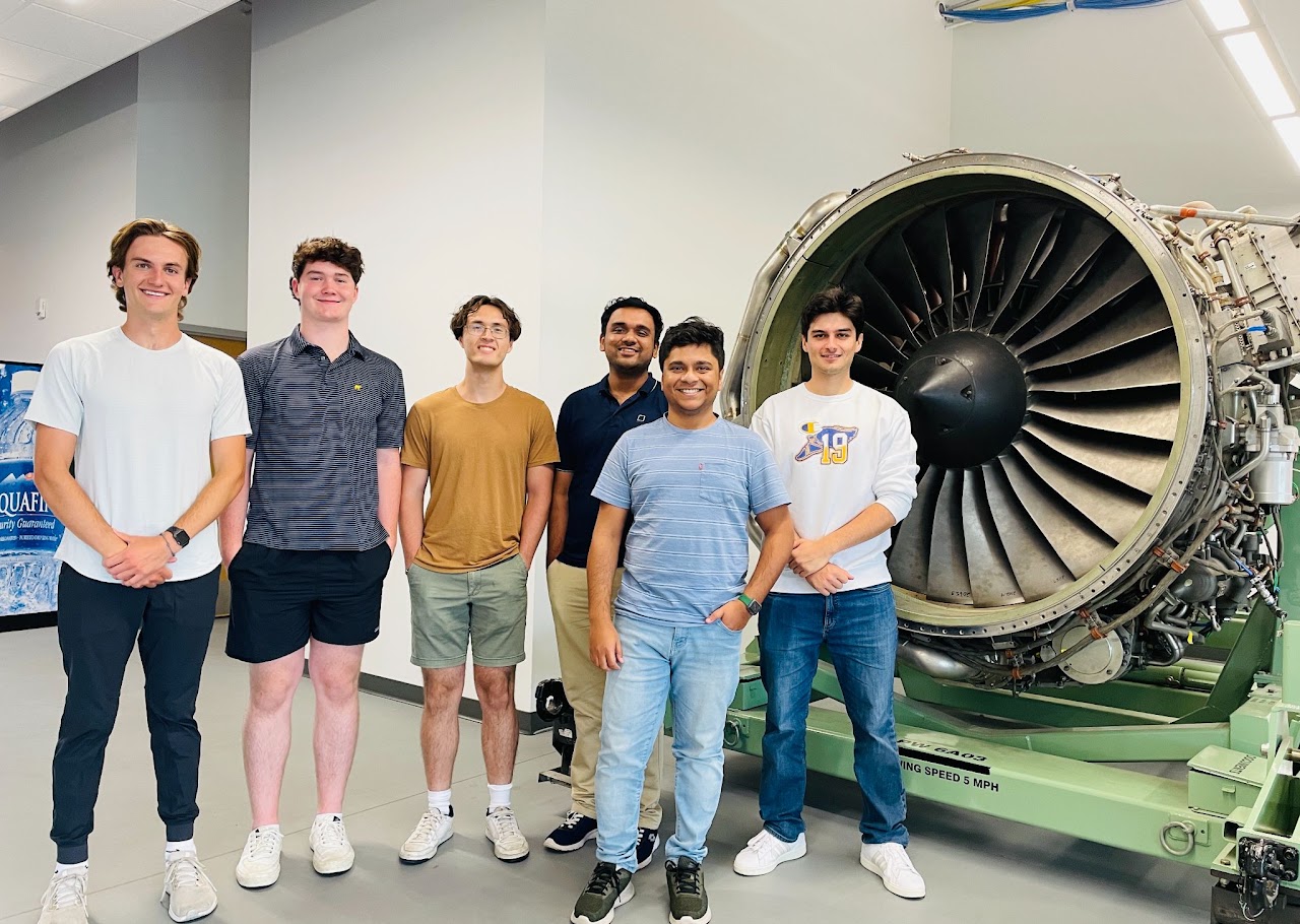 The IMMPACT Lab group next to an aircraft engine, Fall 2025
